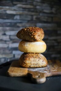 freshly baked bread rolls stacked on board