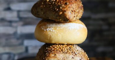 freshly baked bread rolls stacked on board