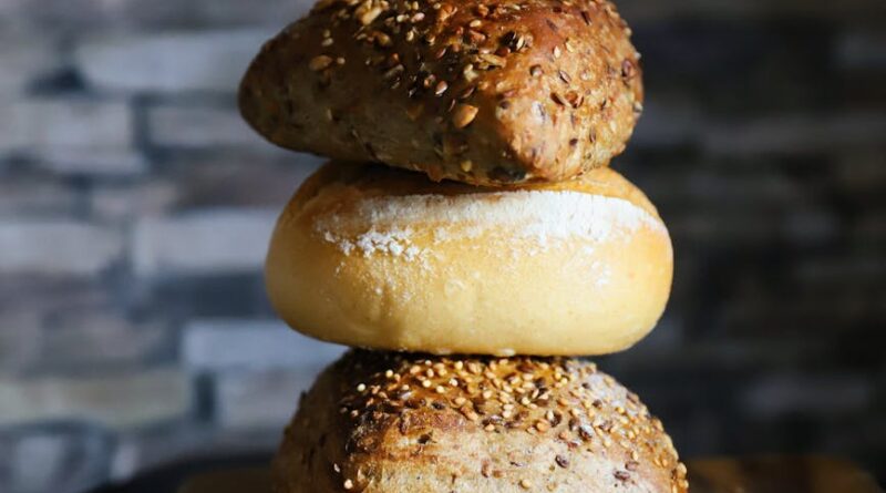 freshly baked bread rolls stacked on board